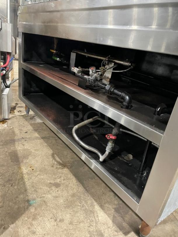 Custom stainless steel 4-well steam table, natural gas powered, with serve-over sneeze guard, hotel pans, on legs.