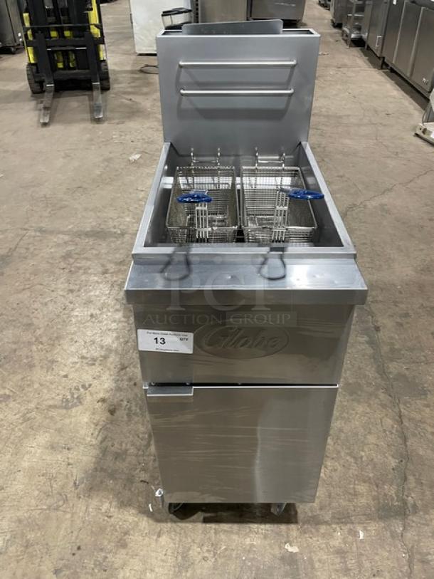 Globe GFF35G stainless steel deep fryer on casters, includes fry baskets, back splash, basket hanger, and serial number 10180137.