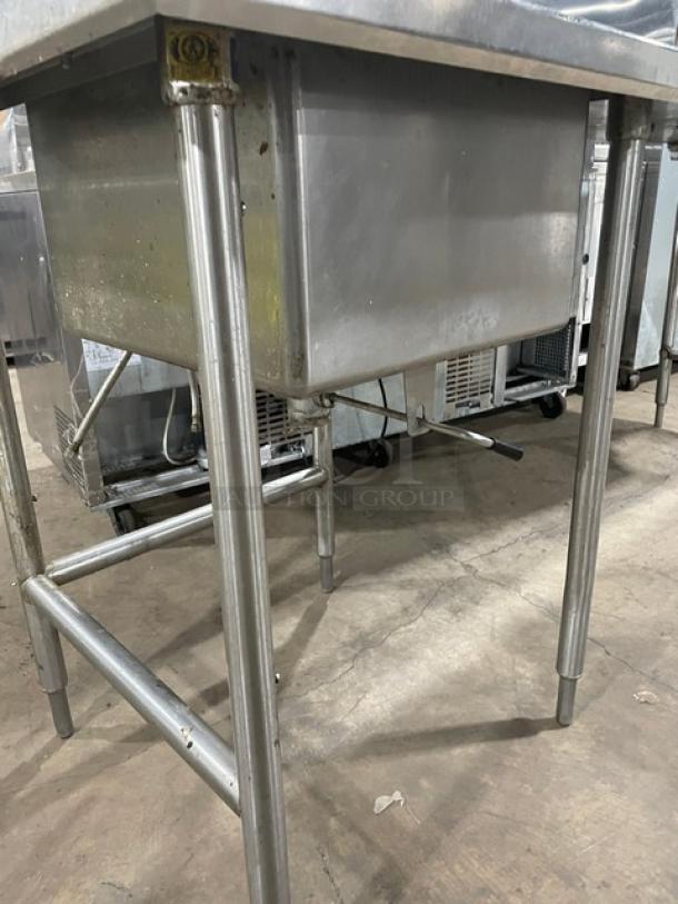 Commercial stainless steel worktop with single compartment sink, backsplash, swing spout faucet, and sturdy legs.