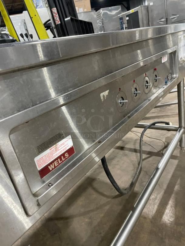 Wells MOD400TDM stainless steel 4-well steamtable, electric-powered, mounted on legs, model and serial labels visible.