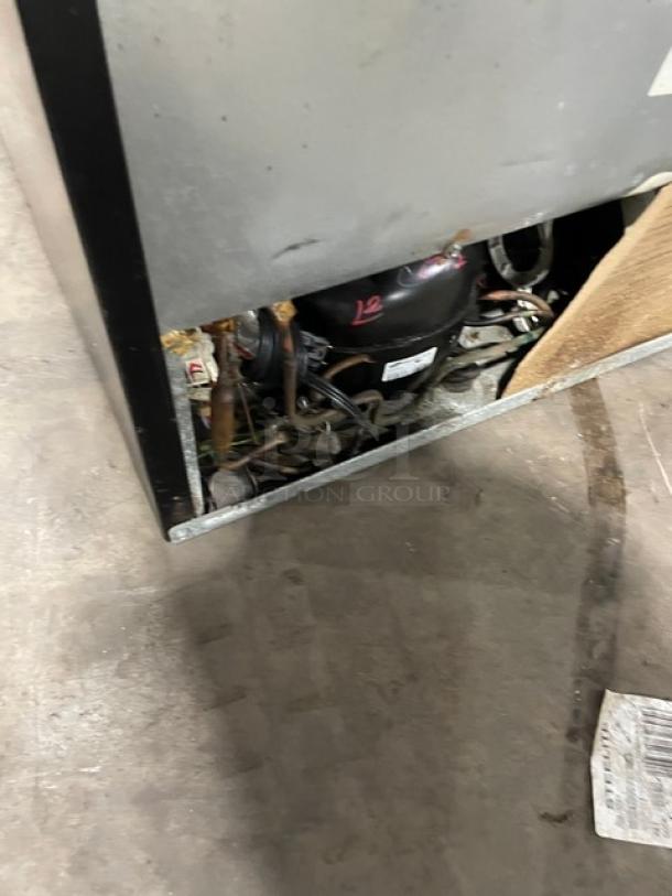 Frigidaire Commercial Dual Section Refrigerator/Freezer, Model FFTR1821QS3, stainless steel, with compressor visible, used condition.
