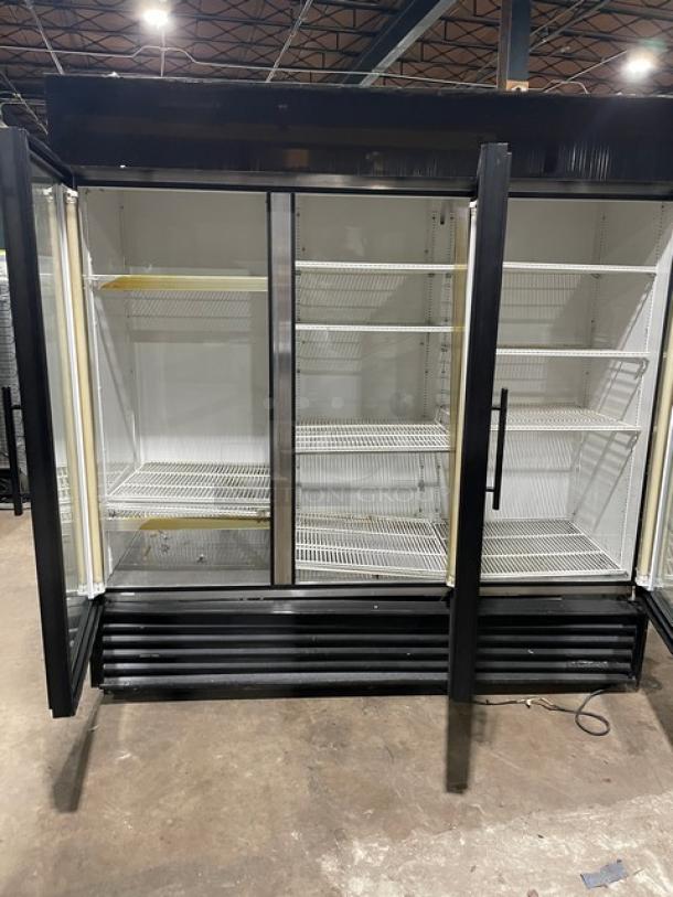 True GDM-72 commercial reach-in merchandiser refrigerator with triple glass swing doors and poly-coated wire racks.