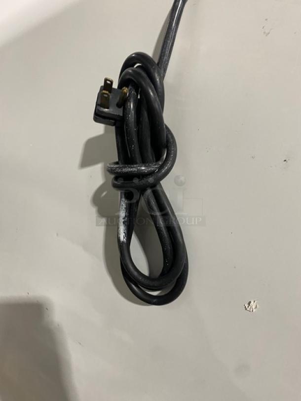 Coiled black power cord for Leer 301UC25MG ice merchandiser freezer, showing three-pronged plug.