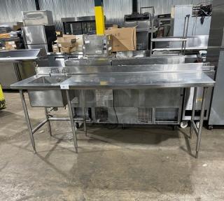 Commercial stainless steel worktop/prep table with single compartment sink, backsplash, and swing spout faucet on sturdy legs.