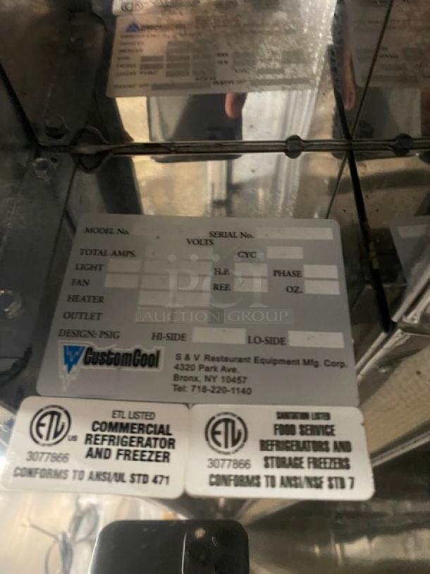 Custom Cool stainless steel refrigerated display case, multi-tiered, open design. Labels show model and compliance details.