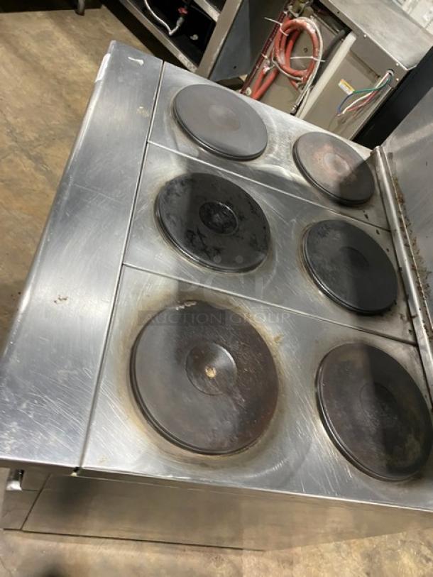 Imperial stainless steel electric 6-burner hot plate range/oven combo with backsplash, overhead salamander shelf, and wired oven rack.