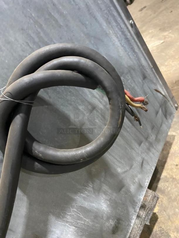 Coiled electrical cable on textured metal surface, possibly part of the Imperial commercial range. No visible labels or markings.