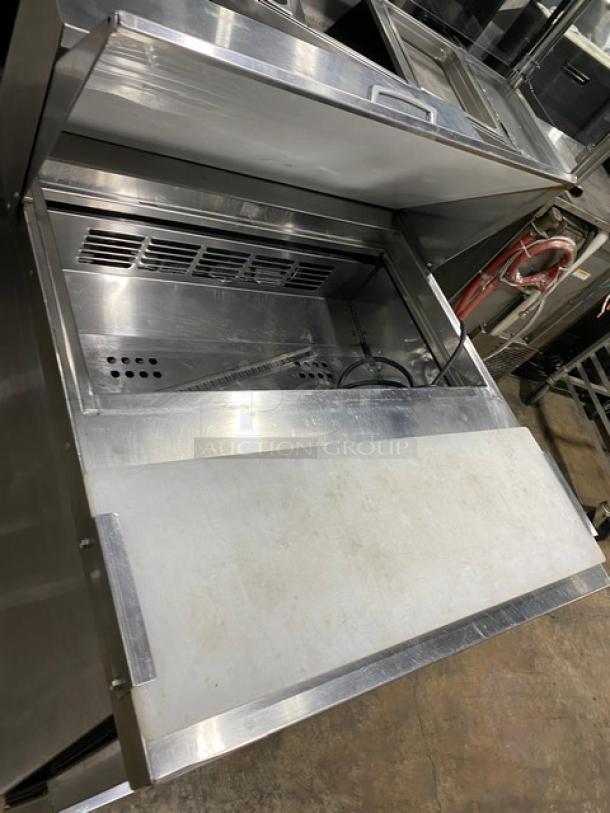 Everest stainless steel refrigerated salad prep table with 2 drawers, integrated cutting board, and casters.