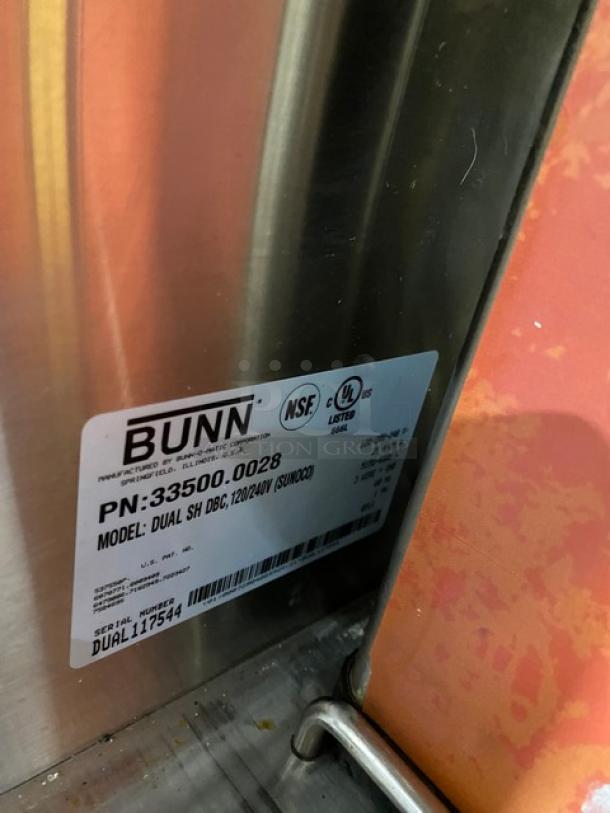 Bunn Dual DBC Series commercial stainless steel automatic twin coffee brewer with funnels and Safety-Fresh servers, model DUALSHDBC, serial number DUAL117544, 120/208-240V, on legs.