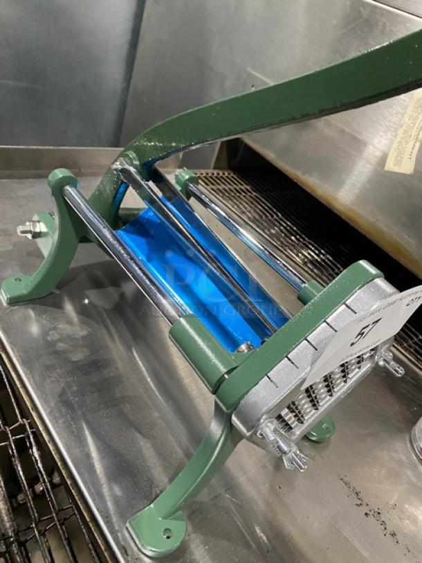 Commercial green heavy-duty manual French fry/potato cutter on legs, featuring a sturdy metal frame with a lever mechanism.