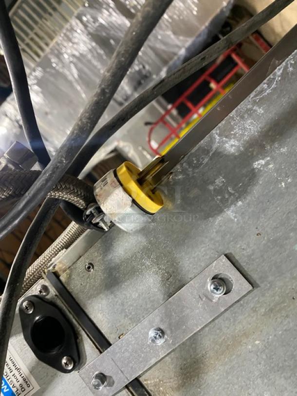 Close-up of Hoshizaki ice machine connections featuring metal and rubber components. Model F-801MAH/B-500PF, serial E05603K.