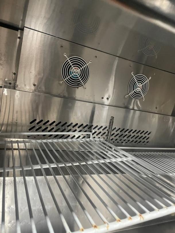 Migali CU48R stainless steel undercounter refrigerator interior with poly-coated wire racks, fans, and vents. Like-new condition.