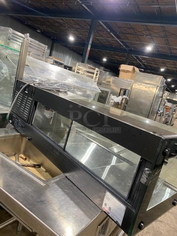 Turbo Air black refrigerated countertop sushi merchandiser with stainless steel interior, rear sliding doors, and visible serial number H2SAS50D1024.