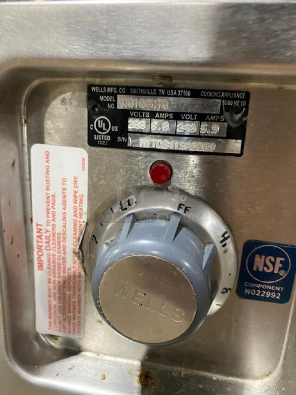 Delfield LiquiTec/Wells drop-in food well controls showing model/serial tags, UL label, NSF mark, and temperature dial.