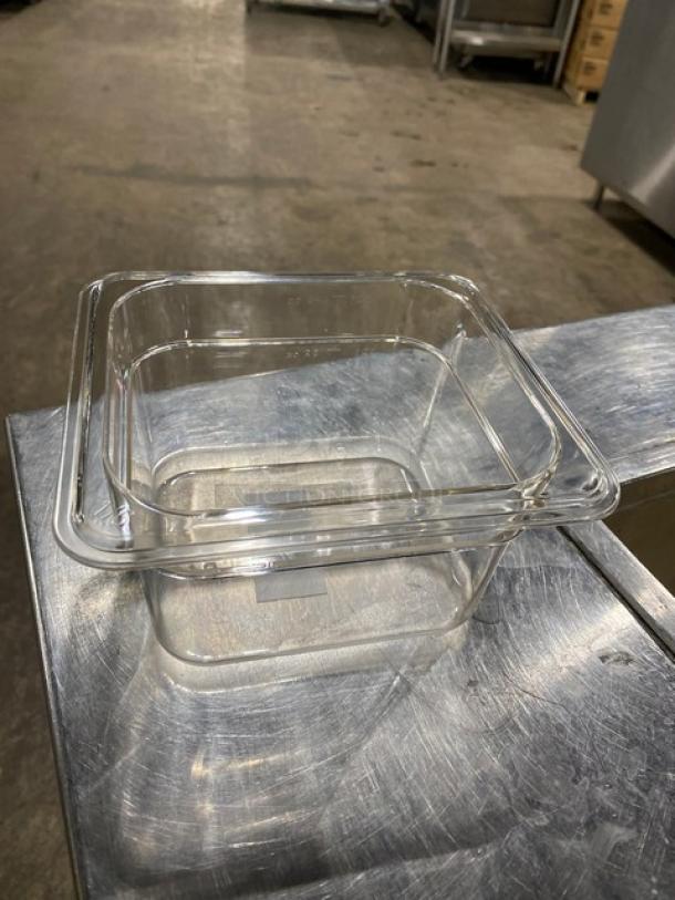NEW Winco SP7604 clear polycarbonate food pan, 1/6-size, 4" deep, pristine condition, on stainless surface.