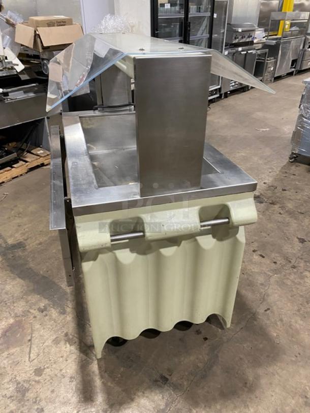 Custom stainless steel commercial salad bar with sneeze guard, folding tray slide, and casters. Excellent condition.