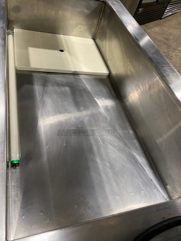 Stainless steel commercial salad bar with sneeze guard, folding tray slide, and casters, in good condition.