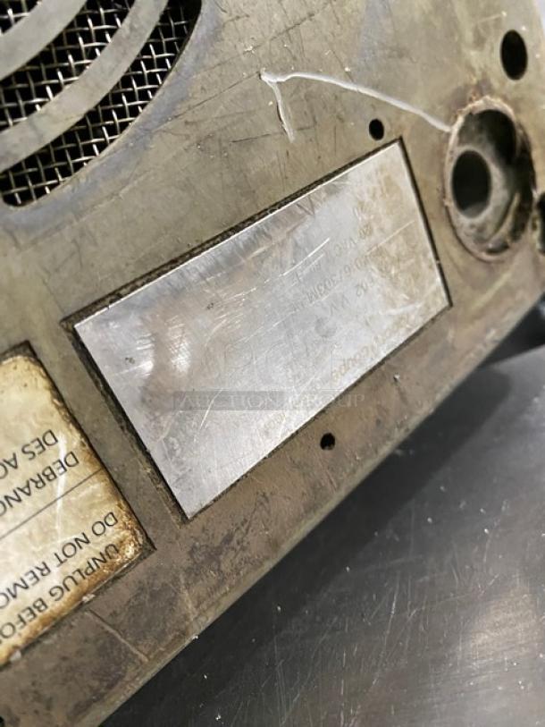 Robot Coupe R602VV food processor base, featuring a visible metal label and ventilation grille. Signs of wear present.