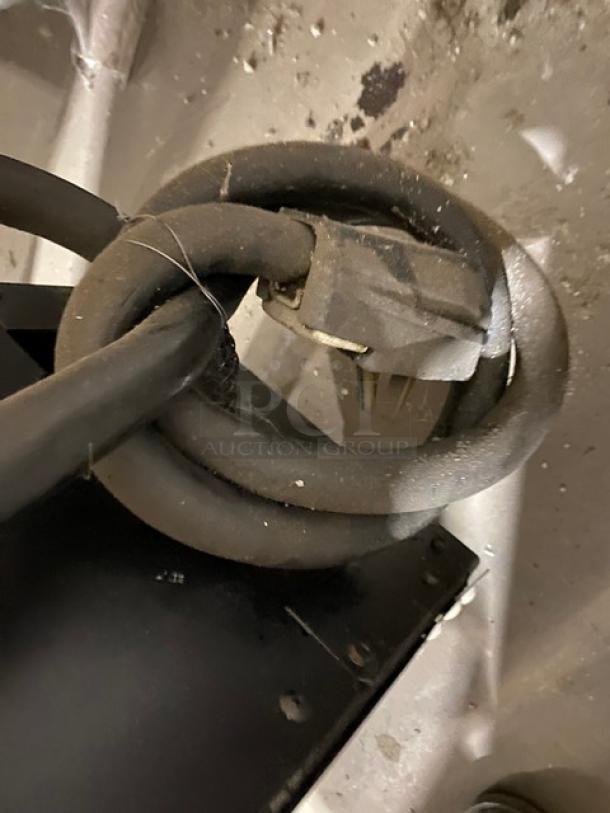 Coiled power cord for Garland model CXBE12 clam shell broiler, showing wear. Plug end visible, suitable for auction inspection.