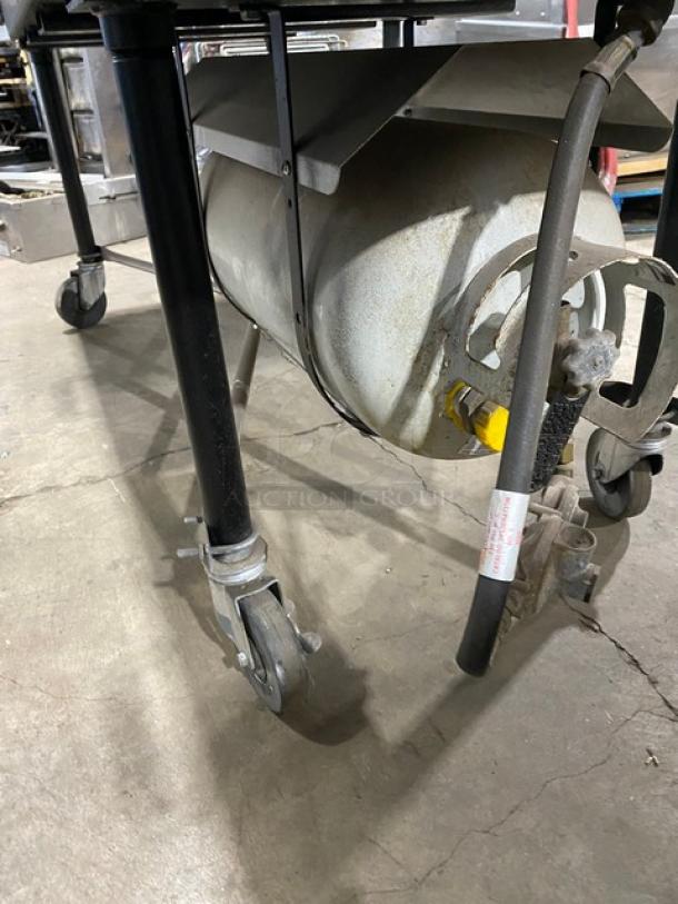 Porta-Grill PG2460II propane BBQ grill on casters, black, with visible propane tank, in used condition.