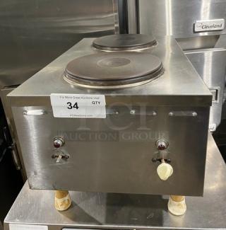Stainless steel electric countertop dual burner hot plate with adjustable legs. Features front-to-back burner layout.