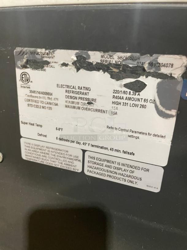 Structural Concepts SBZ6652DR black refrigerated merchandiser. Features visible manufacturer's label with electrical specs and refrigerant info.