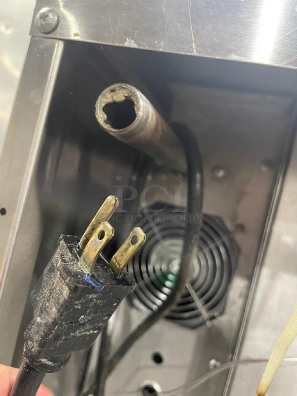 Close-up of an electrical plug and wire near the back vent of the SunFire convection oven, model SCOGS10S.
