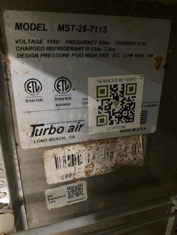 Turbo Air MST-28-711S label showing model, voltage, and service details for a stainless steel refrigerated prep table.