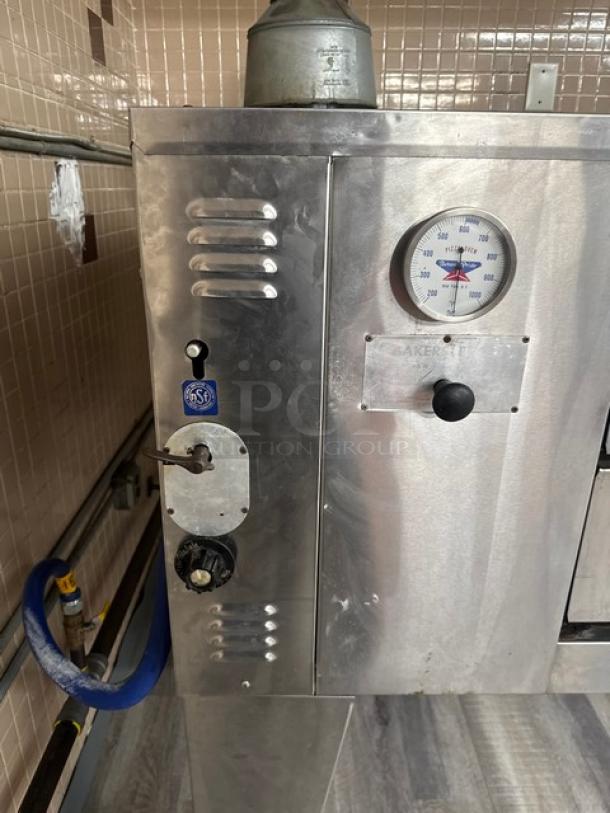 Bakers Pride stainless steel natural gas pizza deck oven, single-stack, 4 pies capacity, with thermostatic control and legs.
