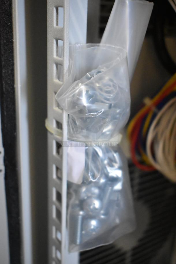 Plastic bag of metal screws and components attached to the Hoffmann N170116G010 Spectracool AC unit.