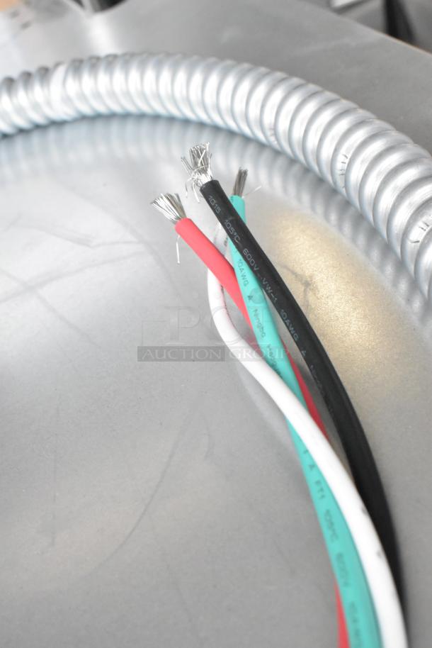 Close-up of electrical wiring for a KoolMore KM-WO30D-SS double-unit wall oven, showing four colored wires and a metal conduit.