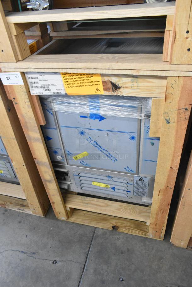 Brand new BKI 52473-1 stainless steel commercial freezer on casters, 115V, 1 Phase. Labeled packaging and warning tags visible.