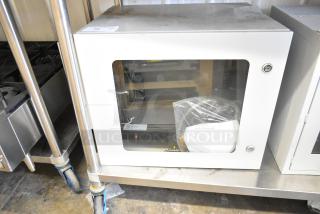 Brand new Telege white metal case with a transparent window, locked door, and visible internal components.