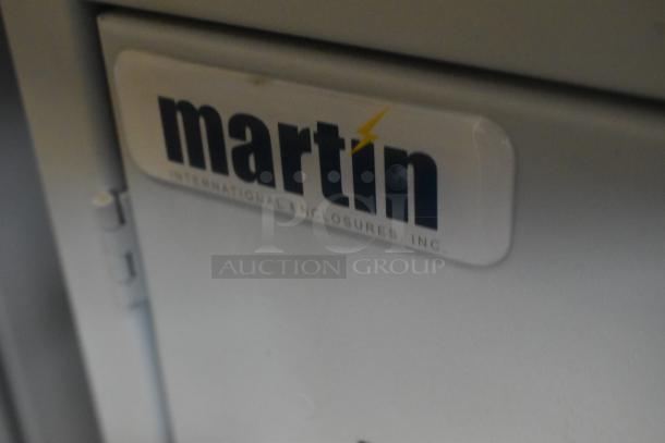 Brand new Martin white metal enclosure, featuring a durable design. Label reads "Martin International Enclosures, Inc."