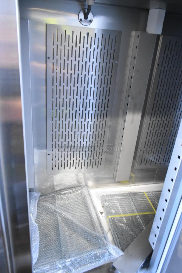 Brand new 2024 Avantco 178SS3FHC stainless steel commercial 3-door freezer interior with poly-coated racks, on casters.