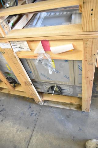 Brand new BKI 52473-1 stainless steel commercial freezer in wooden crate, on casters. Labels show model and voltage details.