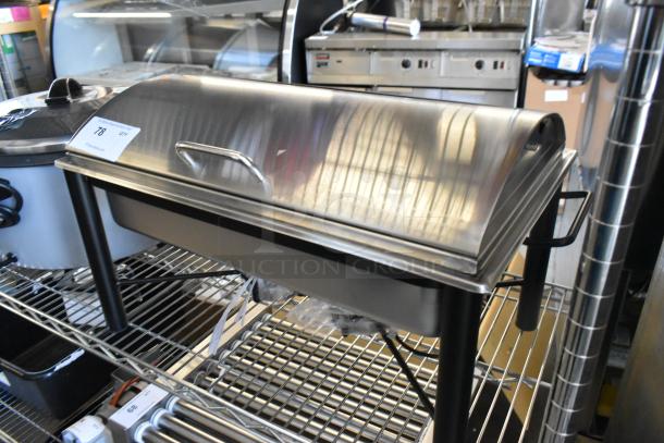 BRAND NEW Stainless Steel Chafer, visible scratch and dent, with lid and handles, on a metal rack, auction label attached.