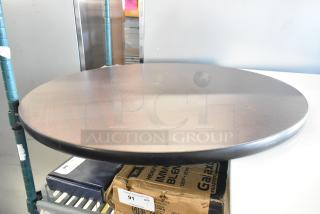 Brand new black round tabletop with slight scratches and dents, sturdy build. Ideal for dining or office use.