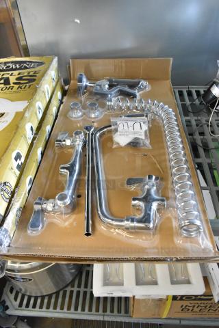 Brand new scratch and dent faucet in packaging, chrome finish, with installation hardware and coiled hose.