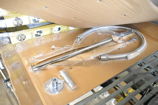 Brand new scratch and dent faucet, chrome finish, includes hose and mounting components, minor packaging wear.