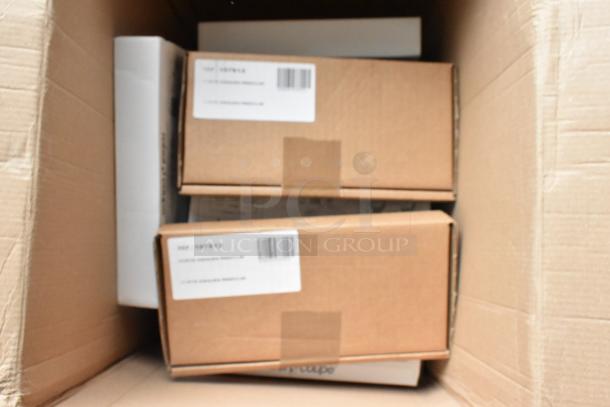 Cardboard box containing 14 brand new Robot Coupe food processor blades in original packaging, each labeled with model numbers 28135W, 28114W, 28112W, 28110W, 28195W, 28063W, 28004W, 28052W, 28056W, 28058W, 28173W, 28062W.
