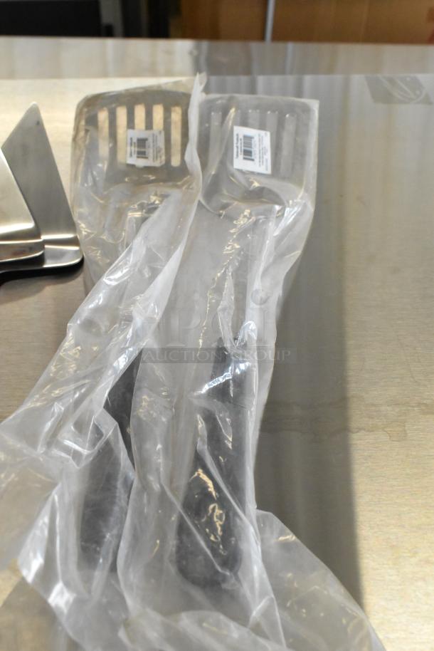 Alt text: Stainless steel utensils including HLB-6 pie server and spatula, brand new with light scratches, in packaging.