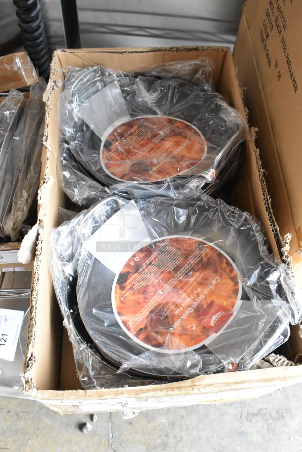 Box of 12 brand new Vollrath 9.5" 10149300 paella pans, scratch and dent condition, original packaging visible.