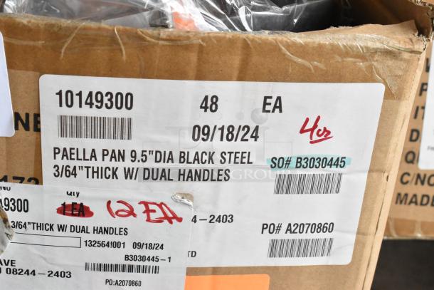 Box of 12 Vollrath 9.5" black steel paella pans, item 10149300, scratch and dent condition, dual handles, tagged for auction.