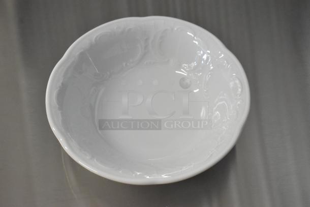 White Bauscher Mozart bowl with intricate rim design, new condition, displayed on a metallic surface.