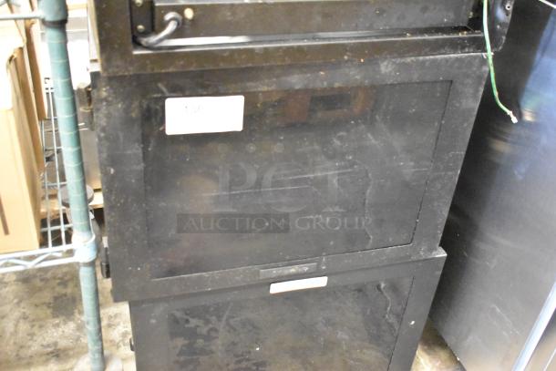 2 Great Lakes black metal cabinets in used condition, visible wear. Features include locks, handles, and panel doors.