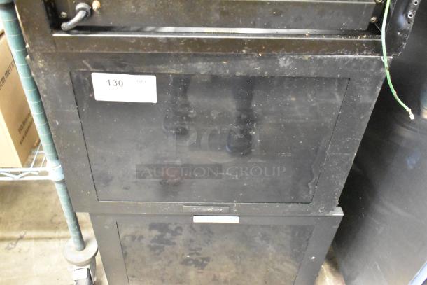Two Great Lakes black metal cabinets with visible wear. Label shows auction lot number 130, indicating item for bidding.