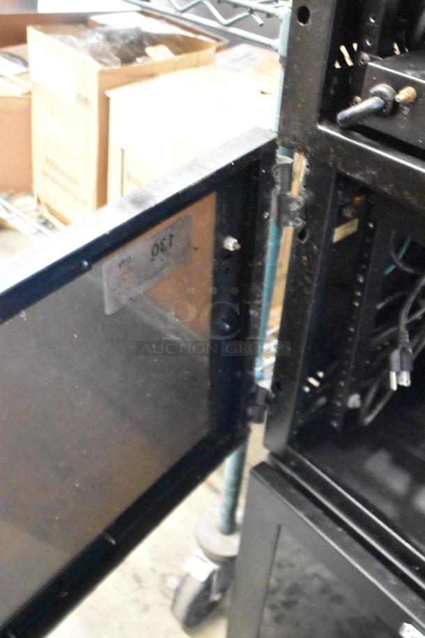 Two Great Lakes black metal cabinets, open door, visible internal shelving, label marked "130", used condition.