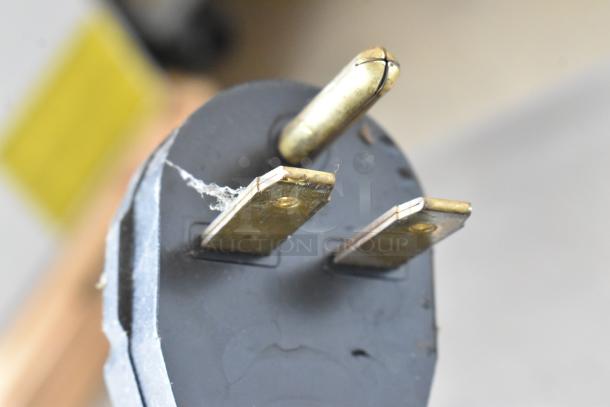 Close-up of a power plug for a Merrychef eikon e4 rapid cook oven, showing three metal prongs and some wear.