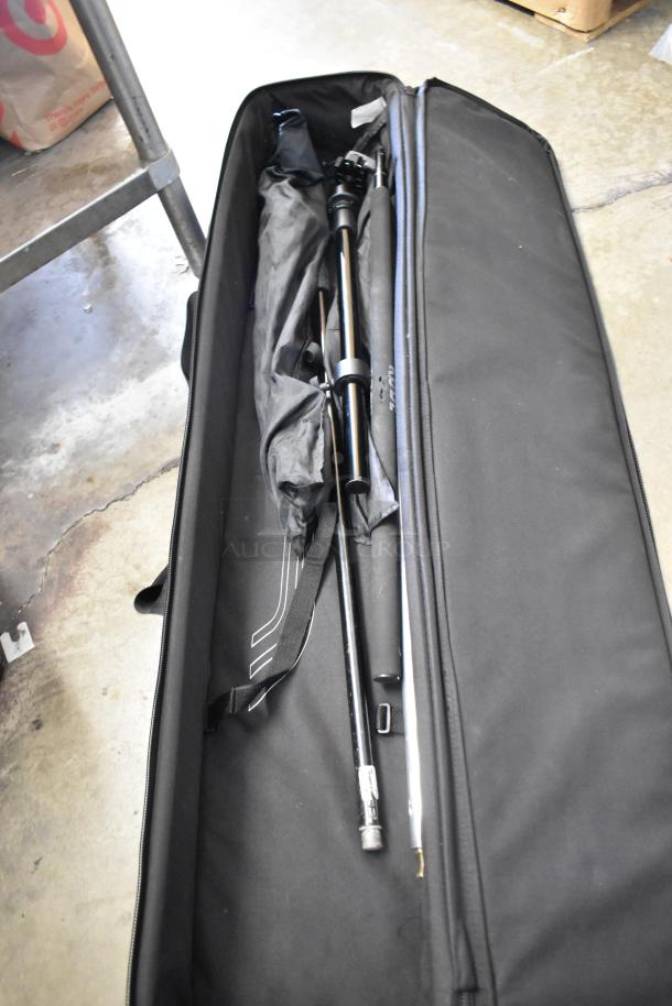 Soft black case containing black poles and equipment, possibly for photography. Shows wear.